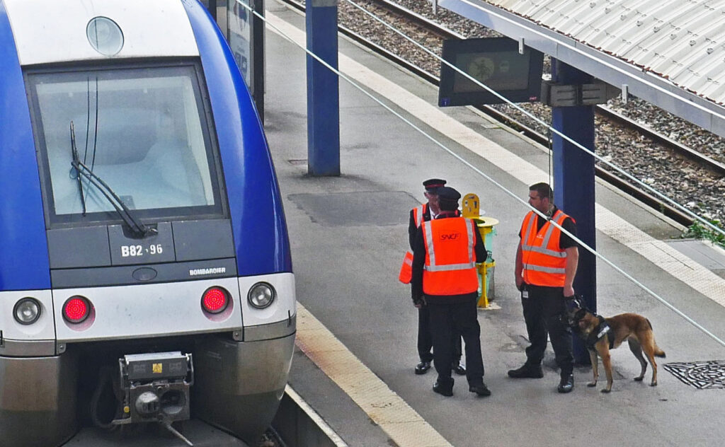 Un train à l'arrêt avec du personnel de sécurité sur le quai.
